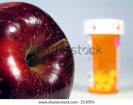 apple in focus with prescription pill bottle faded in background signifying \