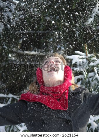 Beautiful blond girl throwing snow into the air.