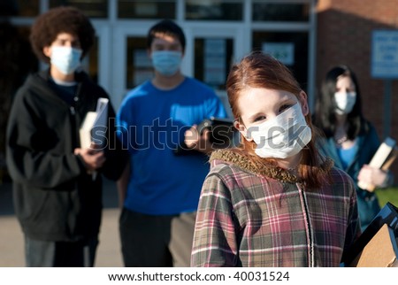 Students of various ethnic backgrounds wearing masks in front of a school