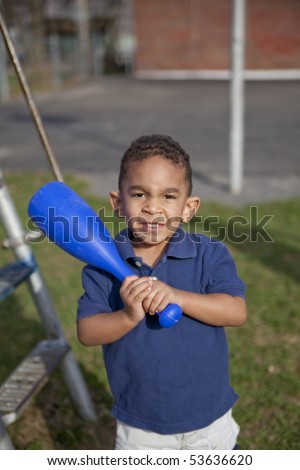 Cute multi-racial boy at the park with a bat