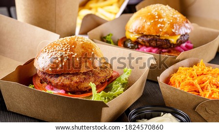 Street food. Meat cutlet burgers are in paper boxes. Food delivery.