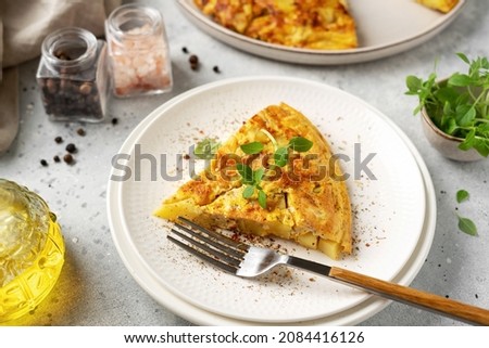 A piece of frittata or potato pie in a ceramic plate on a light culinary background. Traditional Italian delicious homemade egg dish on the kitchen table close-up Foto d'archivio © 