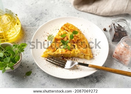 A piece of frittata or potato pie in a ceramic plate on a light culinary background. Traditional Italian delicious homemade egg dish on the kitchen table close-up	 Foto d'archivio © 