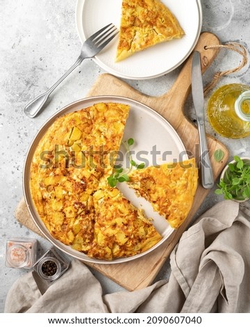 Frittata or potato pie in a ceramic plate on a light culinary background. Traditional Italian delicious homemade egg dish on the kitchen table. Top view Foto d'archivio © 