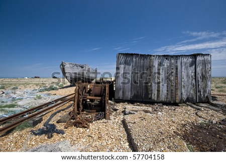 Abandoned seaside place with old boat wreck, fisherman house, service rails shot in sunny day with a blue sky