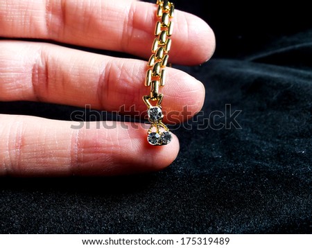 Golden jewelry with diamonds on fingers, isolated towards black background