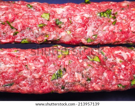 Raw red grounded meat made into shish kebab