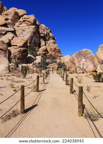 A well-maintained path leads to a hiking trail to historic Hidden Valley in Joshua Tree National Park, California.