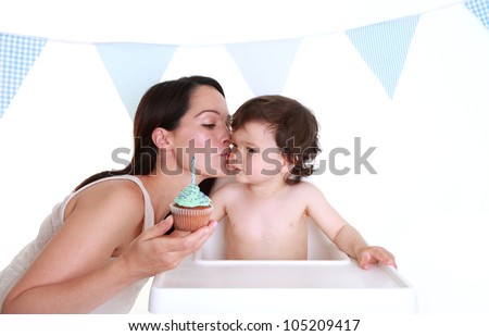 Mother giving baby kiss on cheek on his birthday