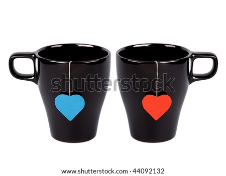 Tea bags with red and blue heart-shaped labels in black cups isolated on white. Tea for two
