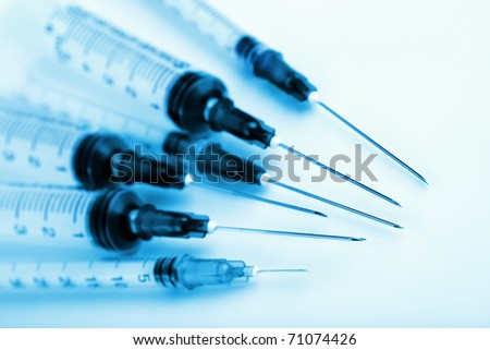 Closeup of syringes toned blue. Selective focus on the needle tips. For medical and laboratory themes