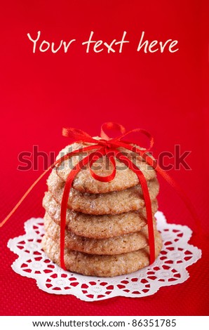 Christmas gingerbread cookies tied with red ribbon on red background