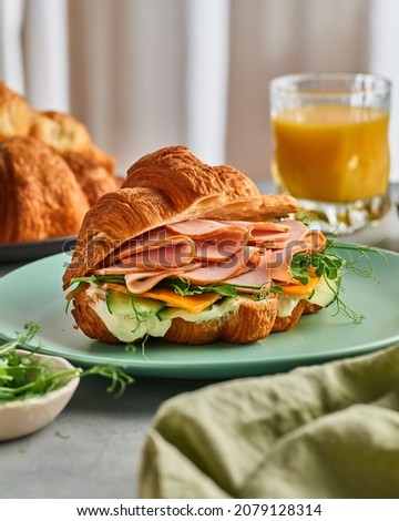 Delicious morning sandwich. Baguette with tomato, salat, doctor's sausage on a wooden substrate. mm. Orange Juice Sandwich. Imagine de stoc © 