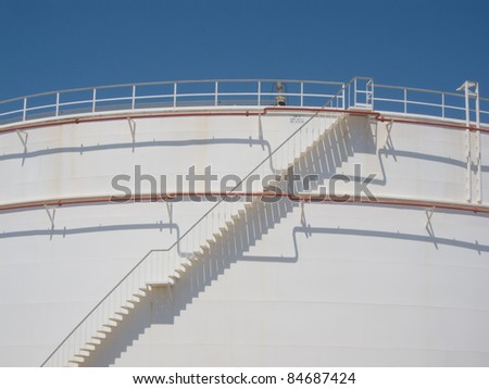 Stair and pipes with shadows at oil tank