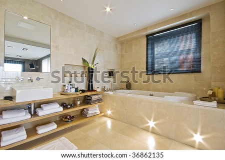 luxury en-suite bathroom with light brown marble and built in plasma tv