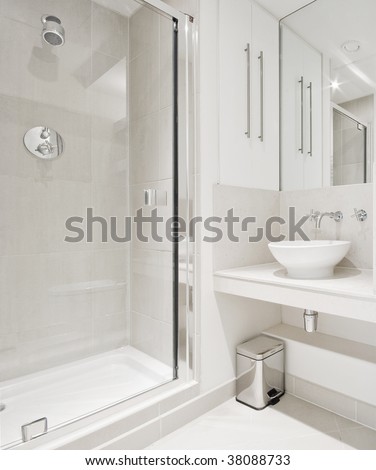 modern bathroom with white ceramic appliances and shower cabin