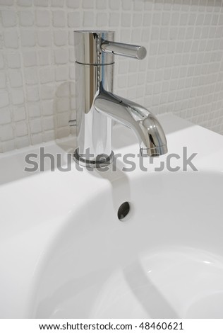 modern design chrome water mixer tap over white ceramic sink