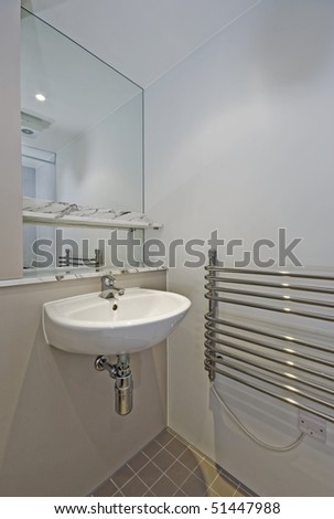 white ceramic hand wash basin and electric towel rail