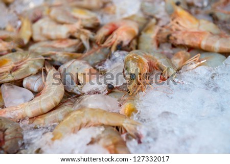 Fresh shrimps on ice for sale at restaurant. Shallow depth of field.