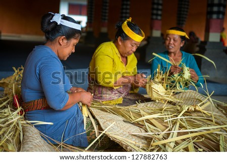 TAMPAK SIRING, BALI, INDONESIA - SEP 21: Women make baskets for balinese traditional offerings to gods in temple Puru Tirtha Empul on Sep 21, 2012 in Tampak Siring, Bali, Indonesia
