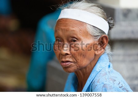 TAMPAK SIRING, BALI, INDONESIA - SEP 21: Old woman takes a part in Balinese community life of traditional offering to gods in temple Puru Tirtha Empul on Sep 21, 2012 in Tampak Siring, Bali, Indonesia