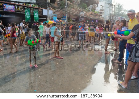 Phuket, Thailand - April 13, 2014: Tourist and residents celebrate Songkran Festival, the Thai New Year by splashing water to each others on Patong streets.