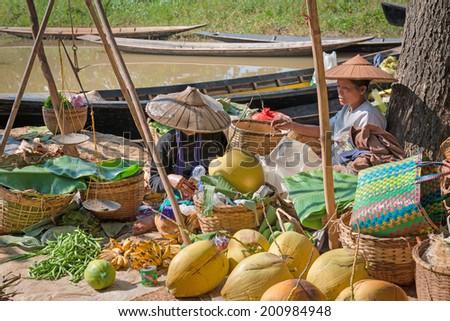 INLE LAKE, MYANMAR (BURMA) - 07 JAN 2014: Local Burmese Intha women sell vegetable and fruits on a traditional open market. Local markets serves most common shopping needs Inle Lake people.