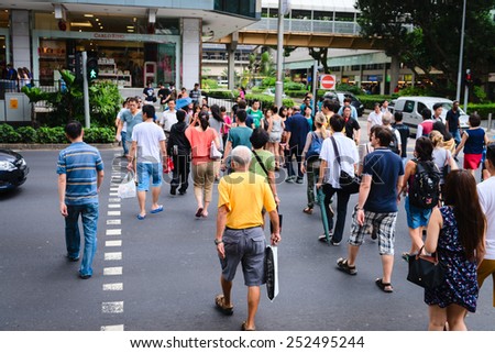 SINGAPORE - 01 JAN 2014: People on pedestrians crossing on famous street Orchard Road in Singapore. Orchard Road is the most popular shopping enclave of Singapore and major tourist attraction.