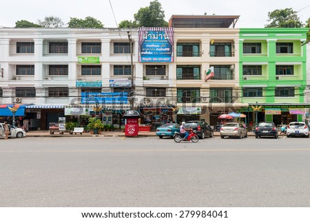 KRABI, THAILAND - 14 OCT 2014: Colorful, commercial building complex in central Krabi town, with roadside parking.
