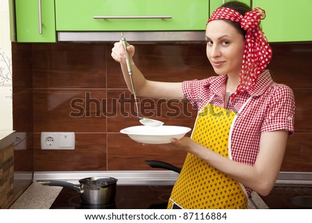 Beautiful happy smiling cooking woman in kitchen interior