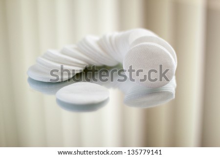 Cotton round cosmetic pads on reflective surface