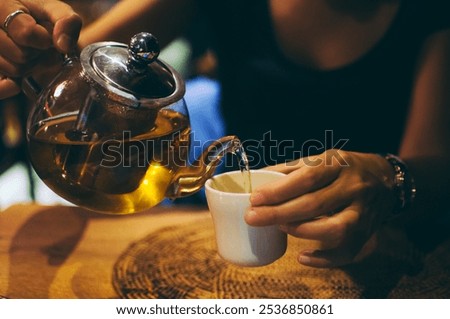 Similar – Image, Stock Photo Woman pouring green tea in mug on wooden table with green herb