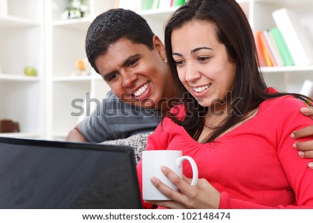Happy young  couple looking at laptop at home