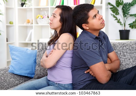 angry couple after  conflict, sitting on couch back to back