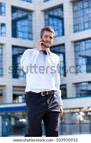 Handsome young business man speaking on the phone , outdoor