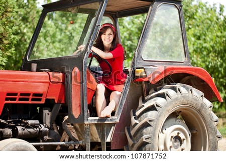 Beautiful woman driving tractor