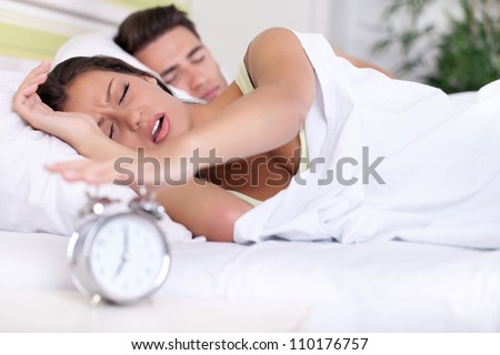 Upset woman turn off alarm clock, Wake up early morning.