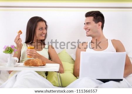 http://image.shutterstock.com/display_pic_with_logo/434191/111366557/stock-photo-young-couple-sitting-on-bed-and-smiling-woman-having-breakfast-and-man-using-laptop-111366557.jpg