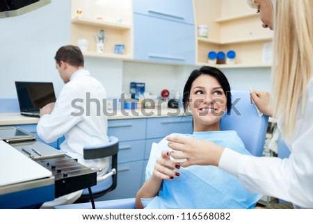 Smiling patient at the dentist office after treatment