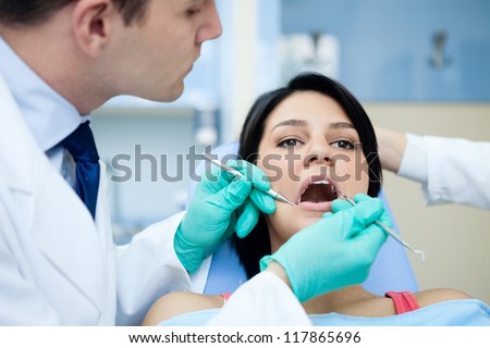 Close-up of patient before oral inspection with hook and mirror near by open mouth
