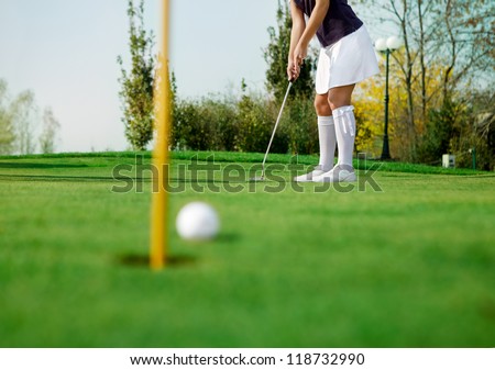 golfer and his ball just inches from the hole