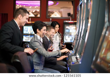 group of young people gambling in the casino on slot machines