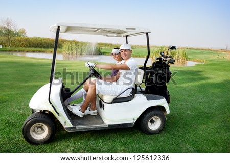 Couple in  driving buggy on golf course
