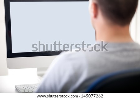 Portrait from behind of young man  using computer