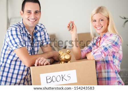 couple with piggy bank and keys with moving boxes, concept saving