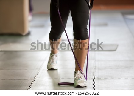 exercising with a resistance band, close up of female legs