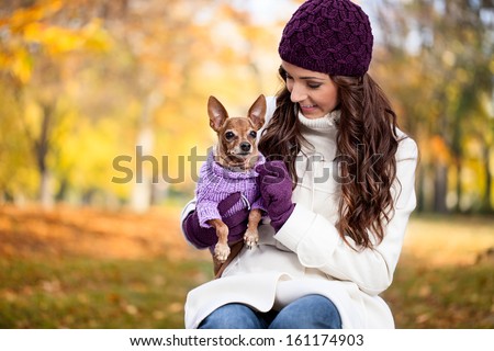 Cute woman with her Miniature Pinscher in autumn forest