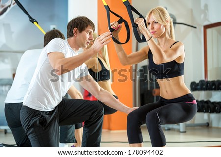 attractive woman doing suspension training with fitness straps