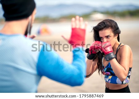 Woman training kickbox with a coach on the beach Stok fotoğraf © 
