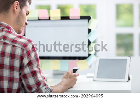 Man front of monitor with sticky notes on it